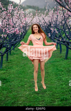 Frau genießen Frühling in der grünen Wiese mit blühenden Bäumen Stockfoto