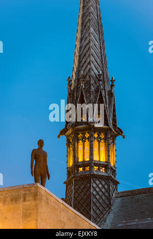 Der Turm der Kapelle Exeter College, Universität Oxford und Antony Gormley Skulptur The Iron Man in der Dämmerung Stockfoto