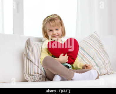lächelndes Mädchen mit roten Herzen zu Hause Stockfoto