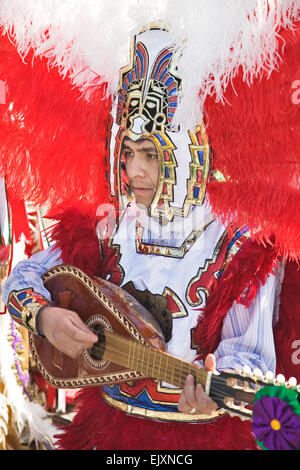Ein bunt kostümierter Musiker spielt und tanzt während der Jungfrau von Guadalupe Festtag in Mexiko-Stadt. Stockfoto