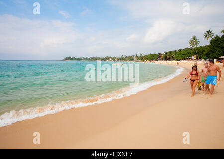 TOURISTEN ZU FUß AM STRAND VON UNAWATUNA Stockfoto