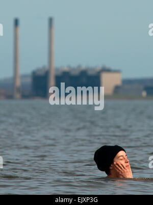 Edinburgh, Schottland. 2. April 2015. Schottland Ostern Wetter Standalone. Zuzana Jerek braucht, um das Wasser auf Portobello direkt am Meer wo ist die Wassertemperatur ca. 7 Grad Celsius. 35 Jahre alte Mutter von drei und ihr Mann Peter geschwommen jeden Tag seit August letzten Jahres. Auch mit 14 Monate alte Tochter Joko abgebildet. Schornsteine aus Cockenzie Power Station können im Hintergrund zu sehen. Bildnachweis: Andrew O'Brien/Alamy Live-Nachrichten Stockfoto