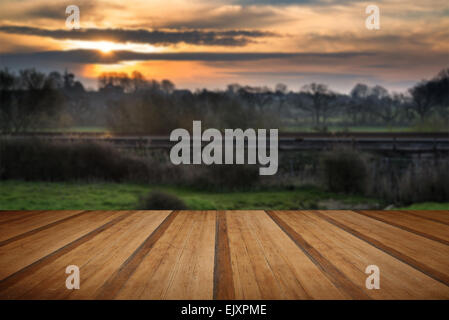 Sonnenaufgang über Bahngleise durch Landschaft mit Holzbohlen Boden Stockfoto