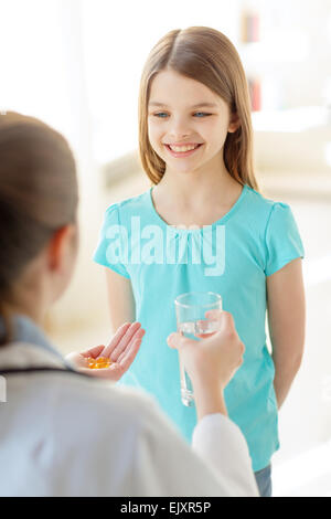 Ärztin, die er Pillen und Wasser für Kind Stockfoto