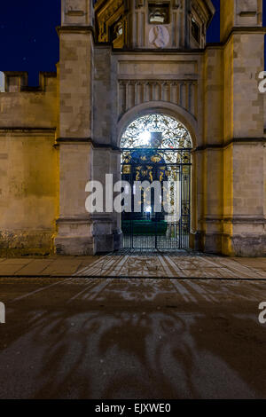 Das Tor zum All Souls College, Universität Oxford Radcliffe Square. Gesehen in der Nacht, wirft schmiedeeiserne Arbeit einen Schatten. Stockfoto