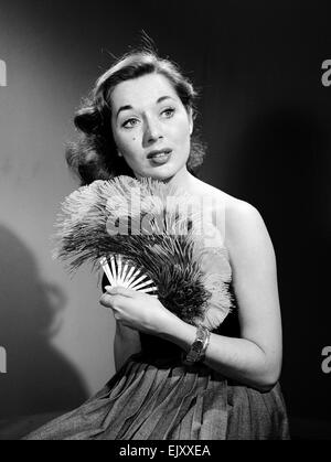 Modell mit Ventilator im trägerlosen Kleid. Modell mit Ventilator im trägerlosen Kleid. c.1964 Stockfoto