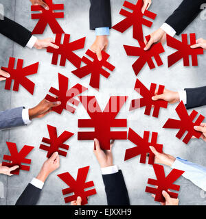 Gruppe von Geschäftsleuten die Hände halten Yen Symbole Stockfoto