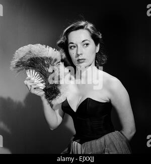 Modell mit Ventilator im trägerlosen Kleid. Modell mit Ventilator im trägerlosen Kleid. c.1964 Stockfoto