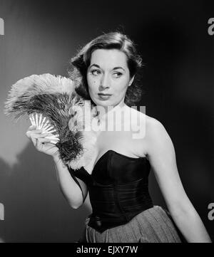 Modell mit Ventilator im trägerlosen Kleid. Modell mit Ventilator im trägerlosen Kleid. c.1964 Stockfoto