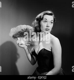 Modell mit Ventilator im trägerlosen Kleid. Modell mit Ventilator im trägerlosen Kleid. c.1964 Stockfoto