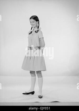 Modell Jennifer Goddard. Braunhaarige Mädchen im karierten Kleid mit Pig tails Stockfoto