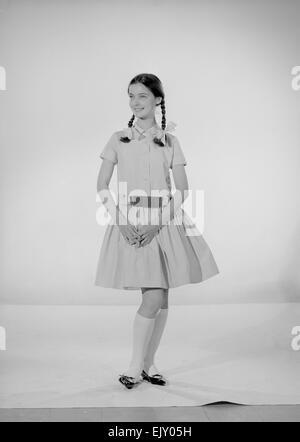 Modell Jennifer Goddard. Braunhaarige Mädchen im karierten Kleid mit Pig tails Stockfoto