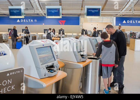 Romulus, Michigan - Passagiere nutzen Automaten Check-in für Flüge mit Delta Air Lines bei Detroit Metro Airport. Stockfoto