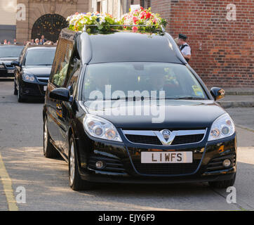 Leichenwagen Fahrt entlang einer Straße bei einer Beerdigung. Stockfoto
