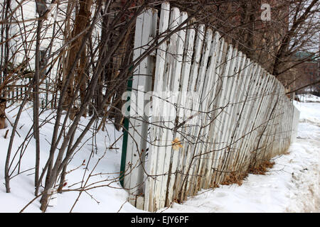 Detail von einem weißen Zaun umgeben von Bäumen in einem verlassenen Haus im Winter in Ontario, Kanada Stockfoto