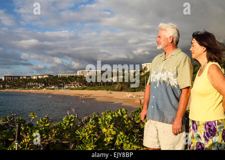 Paar genießt die Aussicht vom Spaziergang am Strand in Wailea, Maui, bei Sonnenuntergang, mit Wailea Beach im Hintergrund Stockfoto