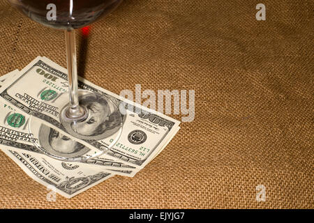 Glas Wein und ein paar 100 US-Dollar-Banknoten auf die alten Gewebe Stockfoto