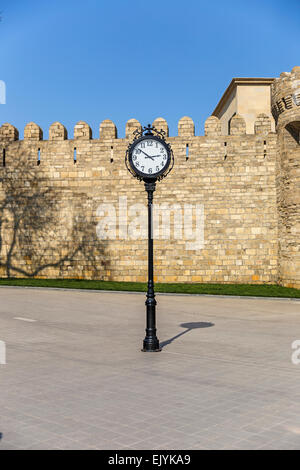 Die Uhr auf dem Hintergrund der alten Festung in Baku Stockfoto