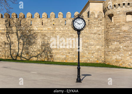 Die Uhr auf dem Hintergrund der alten Festung in Baku Stockfoto