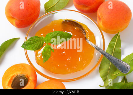Marmelade auf Glasplatte und frischen Aprikosen Stockfoto