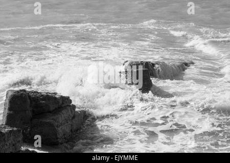 Wellen schlagen an einem sonnigen Tag an einer Wand am Splash Point, Seaford Stockfoto