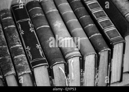 Alte Bücher mit Leder Cover lag auf dem Regal, stilisierte Vintage monochrome Foto Stockfoto