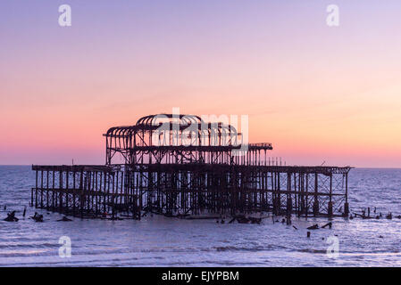 Brightons Skelett West Pier bei Sonnenuntergang mit einem weitgehend klaren bunten Himmel Stockfoto