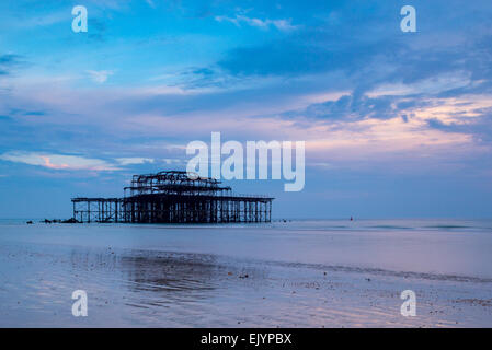 Brightons West Pier bei Ebbe kurz vor Sonnenuntergang, mit der Cloud und Farbe in den Himmel Stockfoto