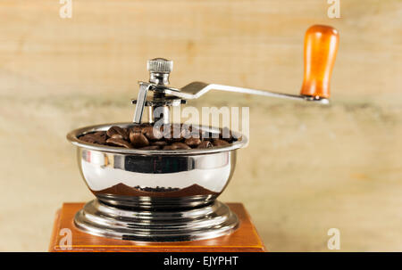 Bohnen in Kaffeemühle mit hölzernen Hintergrund Stockfoto