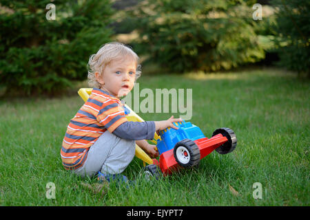 Junge mit Rasenmäher Spielzeug spielen. Stockfoto