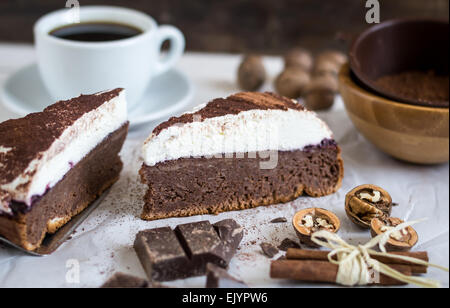 Schokoladenkuchen mit Schlagsahne, bestäubt mit Kakao und Kaffee hautnah Stockfoto