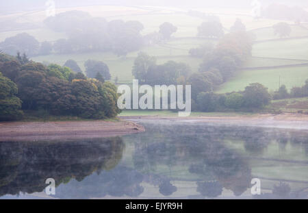 Einem friedlichen Morgen am Ladybower Vorratsbehälter mit Spuren von Nebel auf dem Wasser. Eine wunderschöne Aussicht der Peak District. Stockfoto