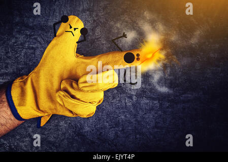 Lustige Smileys an Fingern in schützenden gelb arbeiten Handschuhe, Gun Feuer-Unfall-Konzept Stockfoto