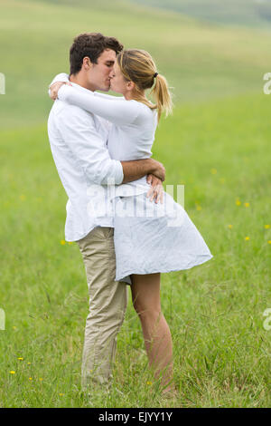 schöne junge Paar küssen auf der grünen Wiese Stockfoto