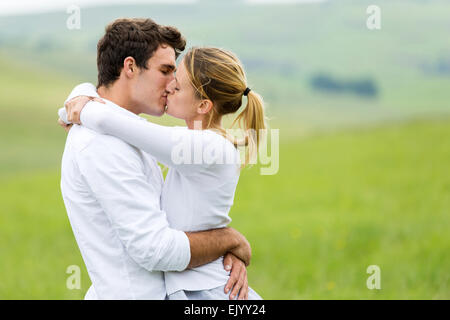 romantisches Paar küssen im Freien auf der Weide Stockfoto
