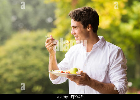 hübscher junger Mann Rührei zum Frühstück Essen Stockfoto