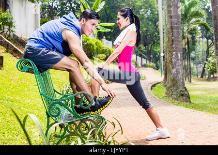 Frau und Mann, eine asiatische paar Ausübung für Fitness Sport in tropischen Park auf Bank Stockfoto