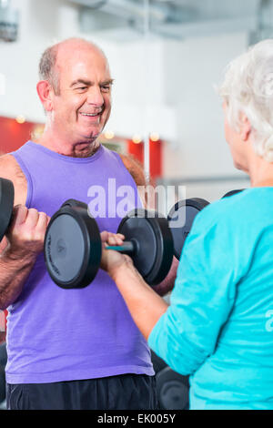 Älteres Paar, Mann und Frau im Fitnessstudio Aufhebung Hanteln im Fitness Übung workout Stockfoto