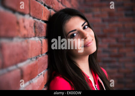 Closeup Portrait eine glückliche Frau, die an die Wand gelehnt Stockfoto