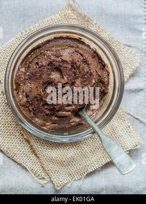 Veganer Avocado Mousse au Chocolat (Pudding) in eine Glasschüssel hautnah. Vertikale Ausrichtung, Ansicht von oben. Stockfoto