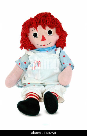 Alte Stoffpuppe mit Zuckerstange isoliert auf weiss. Stockfoto