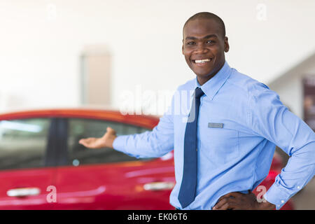 Afrikanische Autoverkäufer steht im Showroom präsentiert Neuwagen Stockfoto