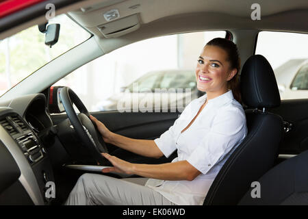 hübsche junge Geschäftsfrau im Auto sitzen sie gerade gekauft Stockfoto