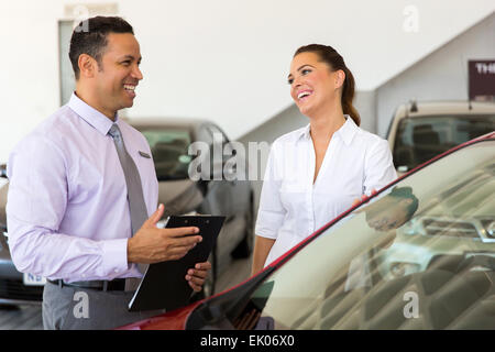 mittleren Alter Autoverkäufer Gespräch mit einem Kunden im showroom Stockfoto