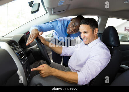 Afrikanischen Verkäufer zeigt neue Autoinnenraum Kunden sitzen im Auto Stockfoto
