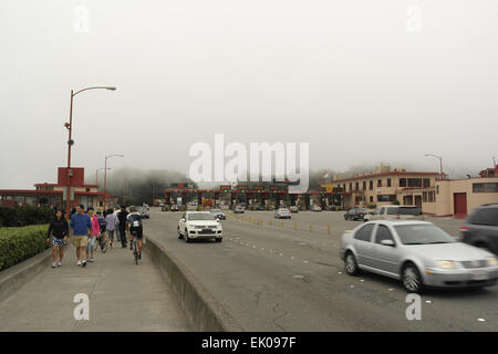 Blick auf fahrende Autos, Gehweg Menschen, Blick nach Süden in Richtung grau Advektion Nebel über Mautstelle der Golden Gate Bridge, San Francisco Stockfoto