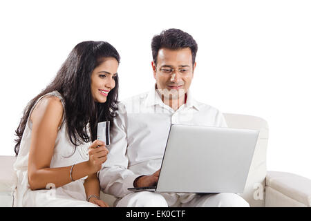 2 indische Ehepaare Haus Laptop mit Kreditkarte online-shopping Stockfoto