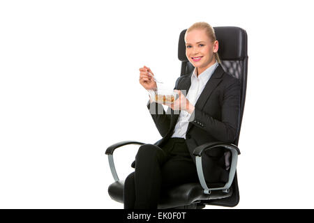 blonde Unternehmerin sitzt auf einem Stuhl und mit Mittagessen Stockfoto