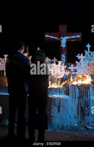 Ein junges Paar betet auf katholischen Friedhof in Larantuka, Insel Flores, Indonesien, nach mass Zeremonie in der Kathedrale-Kirche. Tausende von Menschen, darunter auch aus anderen Städten und Ländern, besuchen eine ganze Woche Zeremonien zur Feier der Karwoche in der kleinen Stadt Larantuka, eines der einflussreichsten Städte in Indonesien in Bezug auf die katholischen Traditionen. Stockfoto