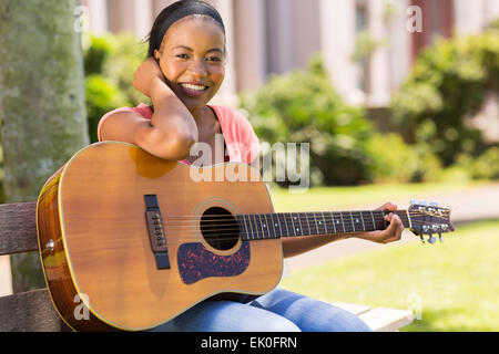 ziemlich afrikanischen Hochschulmädchen üben Gitarre auf dem campus Stockfoto